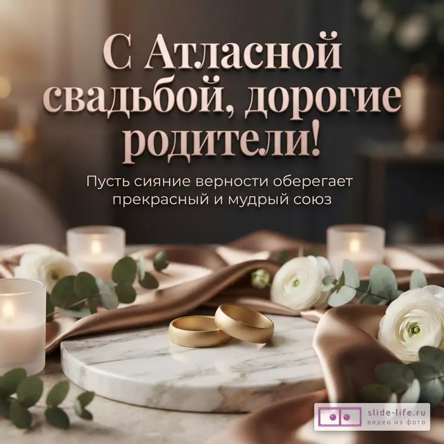 Золотые кольца на мраморной подставке в окружении белых цветов, свечей и атласной ткани с текстом «С Атласной свадьбой, дорогие родители! Пусть сияние верности оберегает прекрасный и мудрый союз».