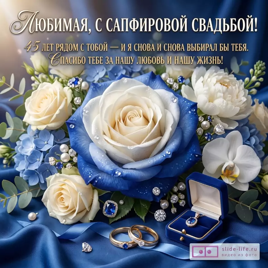 Синий атласный фон, букет белых и голубых роз, кольца и украшения. Текст: «Любимая, с сапфировой свадьбой! 45 лет рядом с тобой — и я снова и снова выбирал бы тебя. Спасибо тебе за нашу любовь и нашу жизнь!»