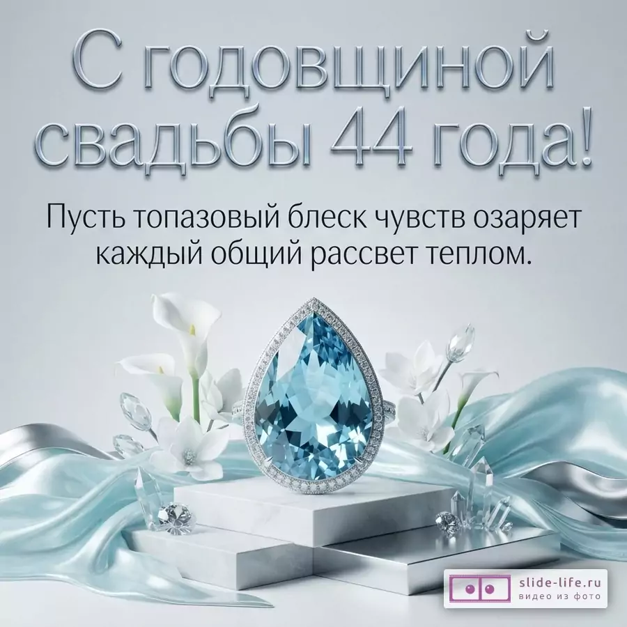 Светло-серый фон, голубая шелковая ткань, белые каллы, кристаллы, кольцо с крупным голубым камнем. Текст: «С годовщиной свадьбы 44 года! Пусть топазовый блеск чувств озаряет каждый общий рассвет теплом.»